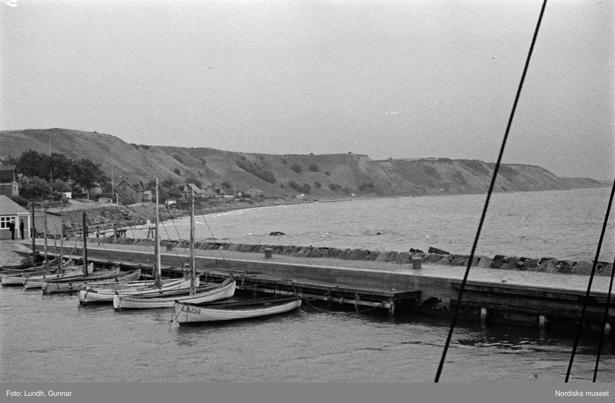 Motiv: Skåne, Malmö;
Fartyg på havet, vy över vattnet och kust med bebyggelse.

Motiv: Skåne, Ven;
Hamn med fartyg, en rykande skorsten, tre laggade kärl står på ett fartygsdäck, vy över hamn med båtar, fartygsdäck med trossar, män och en kvinna står på ett fartygsdäck,