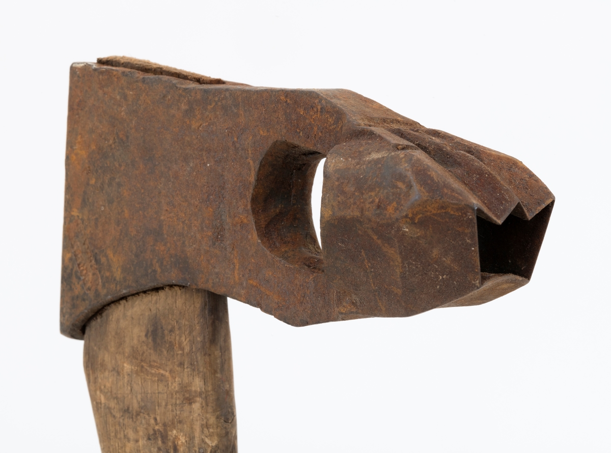 Øks - brukt til merking av fløtingstømmer i målings- og annammingsprosessen som foregikk langs vassdragene i overgangsfasen mellom vinter og vår, da tømmerstokkene etter måling formelt skiftet eier - fra skogeieren som hadde organisert hogst og framkjøring til sagbruk eller treforedlingsbedrift, som kjøpte tømmeret med sikte på videre bearbeiding til produkter som var salgbare på et større marked. 

Øksehodet (den smidde delen) er 14,2 centimeter høyt fra eggpartiet til nakken. Nakkedelen er 7,9 centimeter lang, 2,5 centimeter bred bakerst og 2,3 centimeter bred foran. Øksenakken er noenlunde plan i lengderetningen. På venstre side av den nedre delen av øksehodet (bladet) er det utsmidd en 3,5 centimeter høy «sko» med profilert, fasslipt egg. Denne eggen ble slått inn i yteveden på fløtingsvirket, der den etterlot seg en profilert forsenkning, et symbol som tjente som sorteringsgrunnlag ved lenseanleggene i den nedre delen av vassdraget. På denne øksa minner eggprofilen om omrisset av ei krone. På høyre side av øksehodet finner vi smedstempelet «K. KNUDSEN  MJØNDALEN» samt avbildninger av medaljer denne produsenten hadde oppnådd på utstillinger. Øksehodet er rustent og stempelet er vanskelig lesbart.

Denne øksa har et cirka 60 centimeter langt, noenlunde rett treskaft. Som økseskaft flest er det bredest i høyderetningen og smalest i bredderetningen i den fremre enden, der den er skjeftet. Den bakre delen av skaftet er mer rundoval. Den fremre skaftenden er kilet med en trekile som skulle redusere faren for at øksa løsnet fra skaftet under merkingsarbeidet. Det forkortete firmanavnet «KELL-PARTINGTON» er påført den venstre sida av skaftet (sett i øksebrukerens perspektiv) ved hjelp av svijernstempel. Dette indikerer at øksa har vært brukt til å merke tømmer som ble innkjøpt på vegne av The Kellner Partington Paper Pulp Co. Lim., et engelsk selskap som fram til 1918 eide Borregaard-fabrikken i Sarpsborg. Navnet fortsatte å figurere på merkekartene også etter at Borregaard fikk norsk eierskap, jfr. «Merkekart 1953 for Glommen» i Julius Nygaards skogalmanakk 1954. 

Litt generell informasjon om bruken av merkeøkser i skogbruket finnes under fanen «Opplysninger».