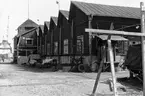 Motiv från varvsområdet Karlsro i Norrköping. Anläggningen på bilden uppfördes omkring 1917 som maskinhall för Norrköpings Varfs- & Werkstads AB. Vid tiden för bilden står byggnaden inför rivning på grund av brandrisk och reorganisering av varvsområdet inför kommande fartygsproduktion.