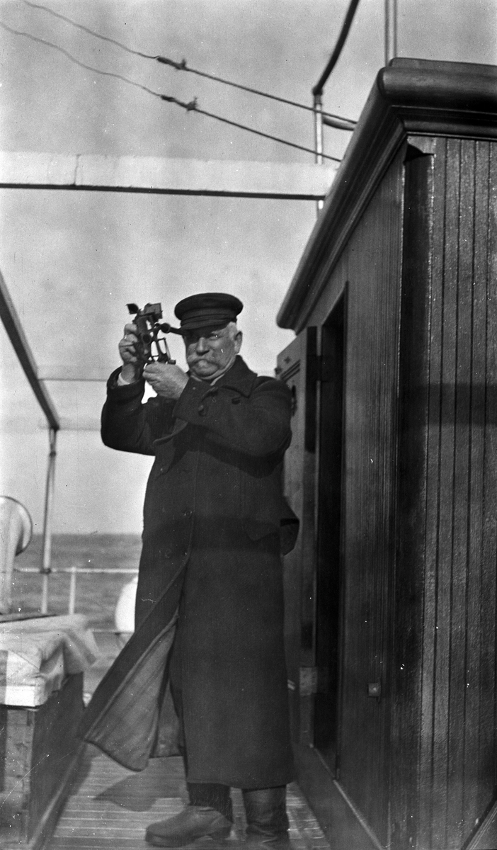 Kaptein Gustav Waage tar ut kursen med en sekstant, ombord på D/S STORFOND.