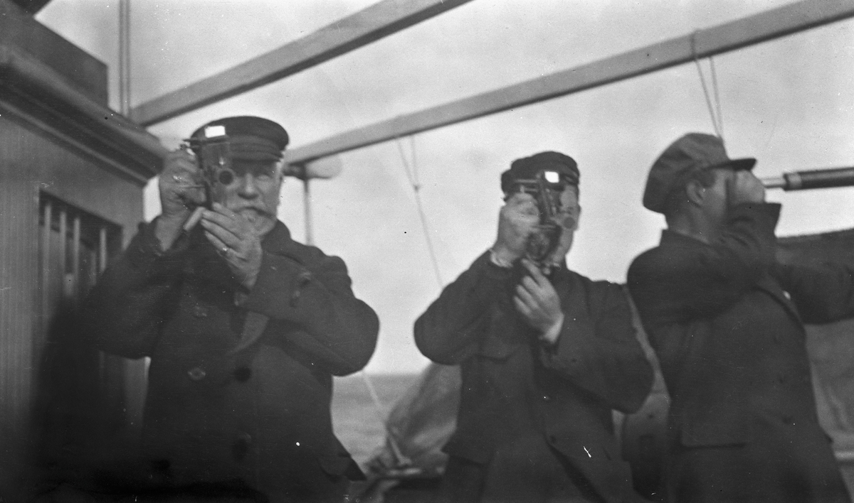 Kaptein Waage og en annen mann tar ut kurs med sekstant. En tredje mann speider i en langkikkert. Om bord på DS STORFOND.