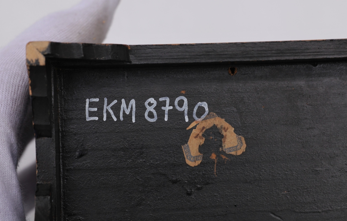 Lite skap med tre skuffer til dukkehus. Fin snekkering, svartmalt, metallbeslag og dekorert med fugler og blomster på alle sider. Svart, gull, sølvfarget.