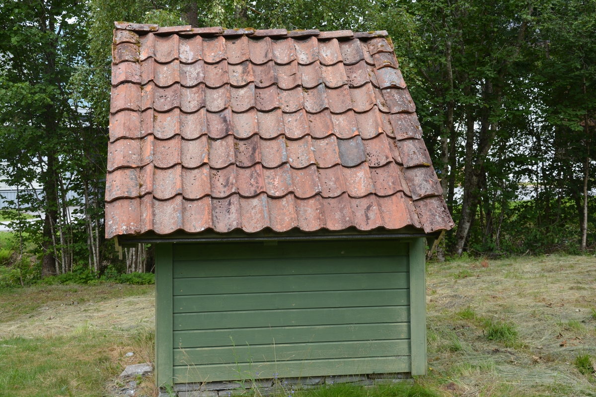 Bygning i eit rom, reisverk. Liggande panel. Dør i gavlveggen. Vindauge over døra. Panel måla mintgrøn (som bygningane i Singerheimen, Olden)