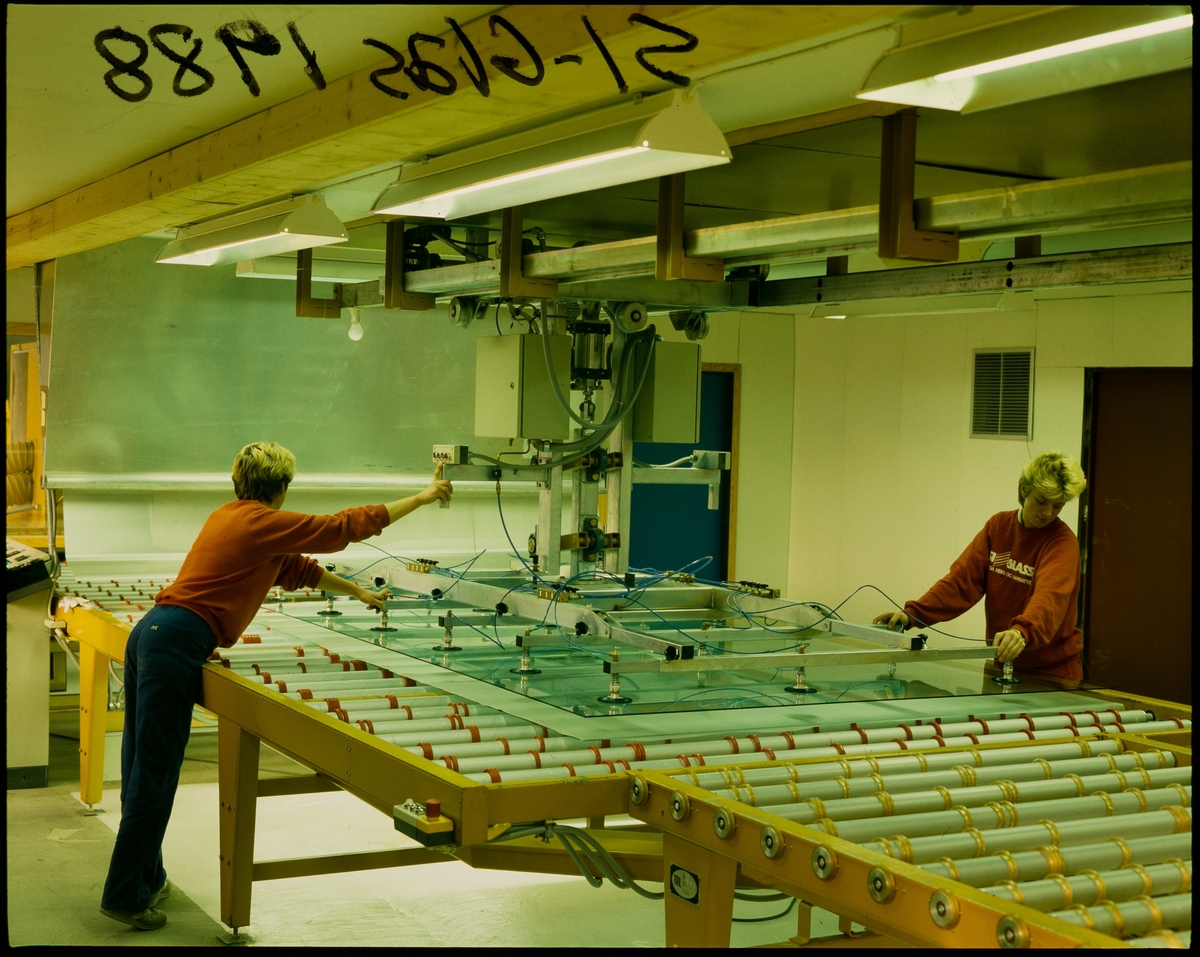 To kvinner produkserer sikkerhetsglass på en fabrikk i Sauda.