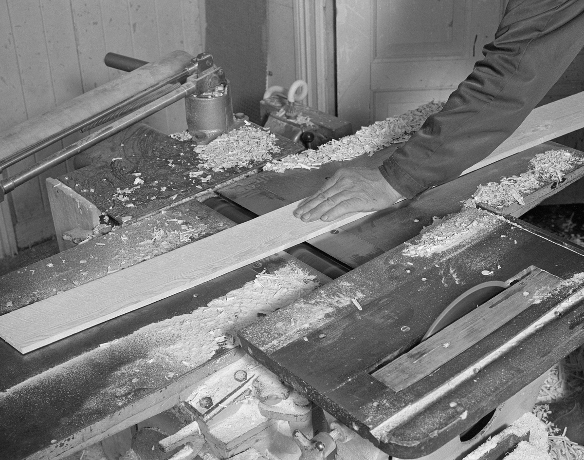 Bygging av fløterbåt (Flisa-båt) november 1984. Fra Glomma fellesfløtingsforenings båtbyggerverksted på Flisa i Åsnes kommune i Solør. Lars Bernhard Olastuen, høvling av bord, bruker maskin.