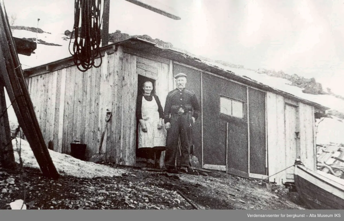 Johan Ingebrigtsen og Jetta foran hytte av rekverk som de bodde i vinteren 45/46 etter krigen.
