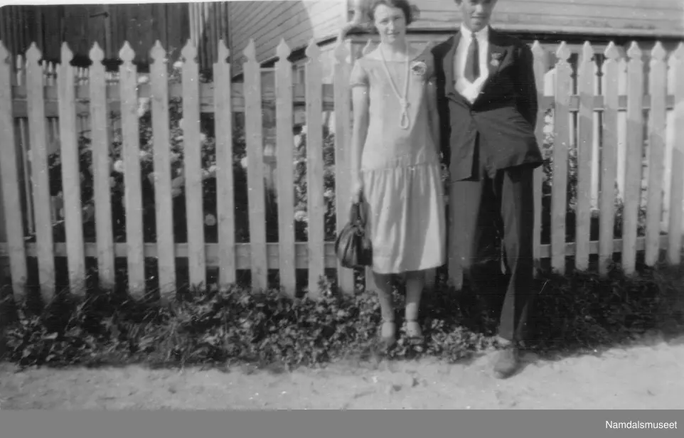 En kvinne og en mann foran et gjerde