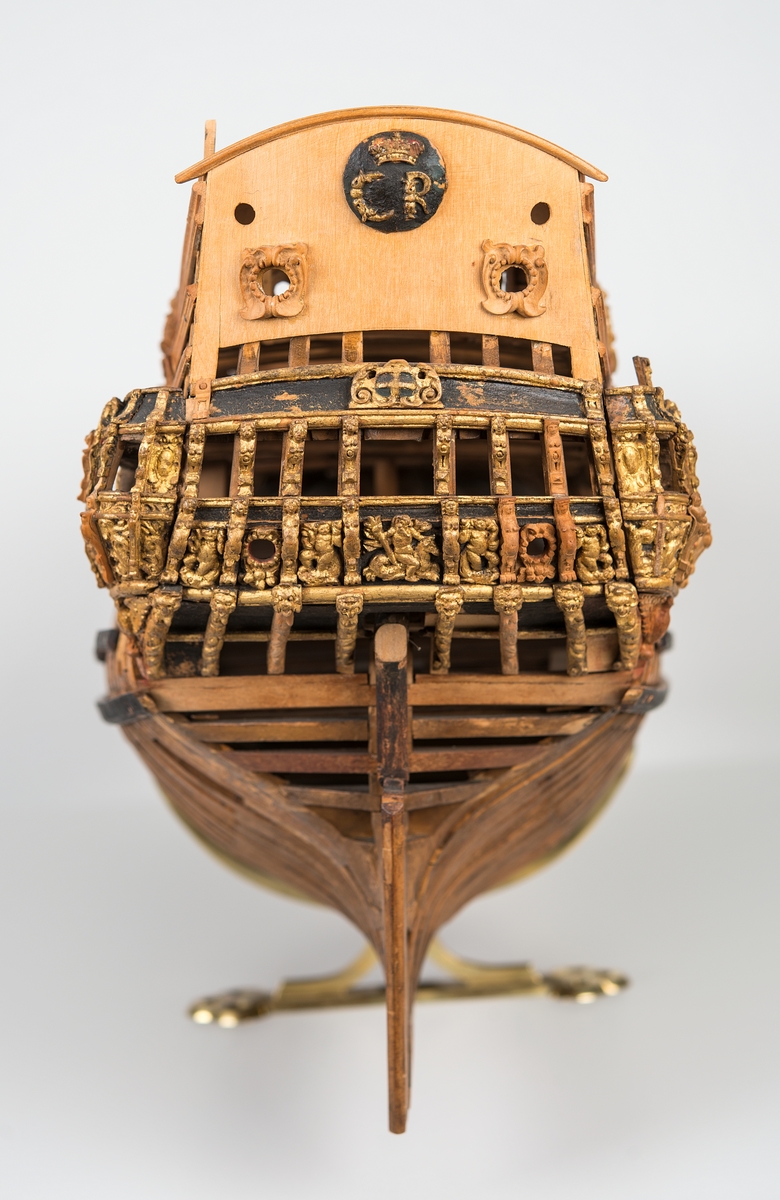 This unplanked model of a three-decker can be dated to c. 1660 and is one of the world's oldest models of a warship. Although not definitively identified, recent research links it to the Swedish ship *Riksäpplet*, designed by the English master shipwright Francis Sheldon and launched in 1661.     
The model was possibly made for Sheldon, who came to Sweden in 1659. He was one of a number of English shipwrights employed by the Swedish crown during the period. Previously, most Swedish warships had been built in the Dutch style.

From around 1660, the English Royal Navy’s administrators commissioned models that were accurately detailed and true to scale. These miniatures, which came to be called Navy or Admiralty Board models, had an unplanked lower hull to emphasise the shape of the underwater body. 

The model was restored by rear-admiral Jacob Hägg in the late 1890s. Missing parts have been reconstructed using lighter coloured wood.

3D model produced by Adam de Kaminski and Vasilis Haroupas for SMTM, 2023
