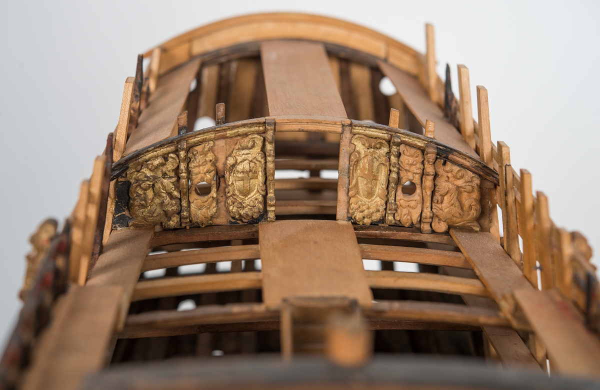 This unplanked model of a three-decker can be dated to c. 1660 and is one of the world's oldest models of a warship. Although not definitively identified, recent research links it to the Swedish ship *Riksäpplet*, designed by the English master shipwright Francis Sheldon and launched in 1661.     
The model was possibly made for Sheldon, who came to Sweden in 1659. He was one of a number of English shipwrights employed by the Swedish crown during the period. Previously, most Swedish warships had been built in the Dutch style.

From around 1660, the English Royal Navy’s administrators commissioned models that were accurately detailed and true to scale. These miniatures, which came to be called Navy or Admiralty Board models, had an unplanked lower hull to emphasise the shape of the underwater body. 

The model was restored by rear-admiral Jacob Hägg in the late 1890s. Missing parts have been reconstructed using lighter coloured wood.

3D model produced by Adam de Kaminski and Vasilis Haroupas for SMTM, 2023
