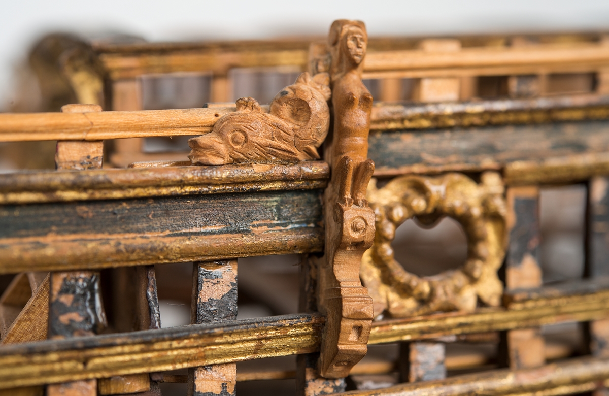 This unplanked model of a three-decker can be dated to c. 1660 and is one of the world's oldest models of a warship. Although not definitively identified, recent research links it to the Swedish ship *Riksäpplet*, designed by the English master shipwright Francis Sheldon and launched in 1661.     
The model was possibly made for Sheldon, who came to Sweden in 1659. He was one of a number of English shipwrights employed by the Swedish crown during the period. Previously, most Swedish warships had been built in the Dutch style.

From around 1660, the English Royal Navy’s administrators commissioned models that were accurately detailed and true to scale. These miniatures, which came to be called Navy or Admiralty Board models, had an unplanked lower hull to emphasise the shape of the underwater body. 

The model was restored by rear-admiral Jacob Hägg in the late 1890s. Missing parts have been reconstructed using lighter coloured wood.

3D model produced by Adam de Kaminski and Vasilis Haroupas for SMTM, 2023

