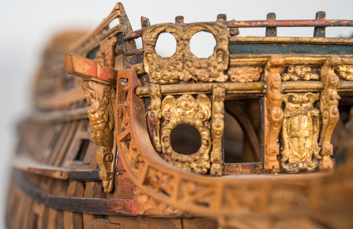 This unplanked model of a three-decker can be dated to c. 1660 and is one of the world's oldest models of a warship. Although not definitively identified, recent research links it to the Swedish ship *Riksäpplet*, designed by the English master shipwright Francis Sheldon and launched in 1661.     
The model was possibly made for Sheldon, who came to Sweden in 1659. He was one of a number of English shipwrights employed by the Swedish crown during the period. Previously, most Swedish warships had been built in the Dutch style.

From around 1660, the English Royal Navy’s administrators commissioned models that were accurately detailed and true to scale. These miniatures, which came to be called Navy or Admiralty Board models, had an unplanked lower hull to emphasise the shape of the underwater body. 

The model was restored by rear-admiral Jacob Hägg in the late 1890s. Missing parts have been reconstructed using lighter coloured wood.

3D model produced by Adam de Kaminski and Vasilis Haroupas for SMTM, 2023
