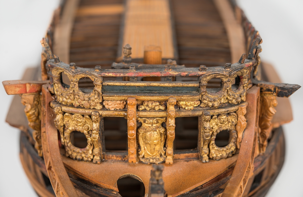 This unplanked model of a three-decker can be dated to c. 1660 and is one of the world's oldest models of a warship. Although not definitively identified, recent research links it to the Swedish ship *Riksäpplet*, designed by the English master shipwright Francis Sheldon and launched in 1661.     
The model was possibly made for Sheldon, who came to Sweden in 1659. He was one of a number of English shipwrights employed by the Swedish crown during the period. Previously, most Swedish warships had been built in the Dutch style.

From around 1660, the English Royal Navy’s administrators commissioned models that were accurately detailed and true to scale. These miniatures, which came to be called Navy or Admiralty Board models, had an unplanked lower hull to emphasise the shape of the underwater body. 

The model was restored by rear-admiral Jacob Hägg in the late 1890s. Missing parts have been reconstructed using lighter coloured wood.

3D model produced by Adam de Kaminski and Vasilis Haroupas for SMTM, 2023
