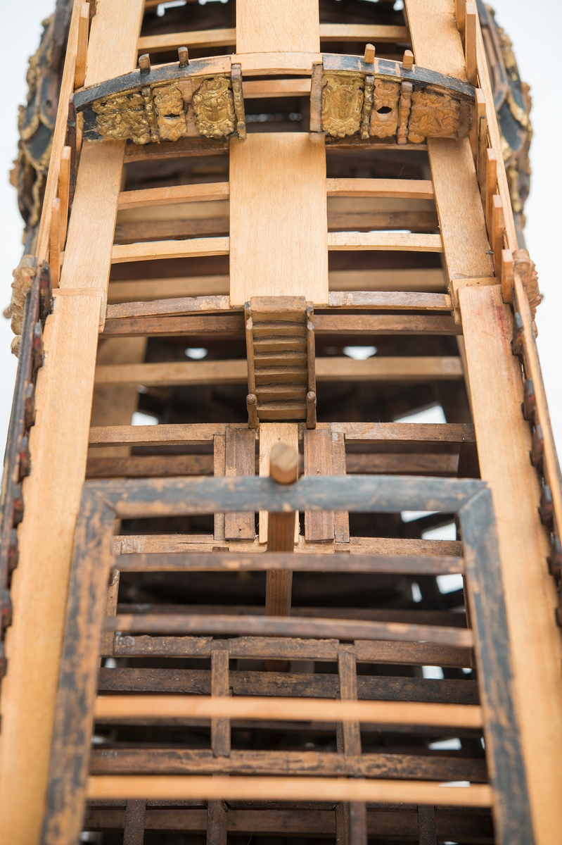 This unplanked model of a three-decker can be dated to c. 1660 and is one of the world's oldest models of a warship. Although not definitively identified, recent research links it to the Swedish ship *Riksäpplet*, designed by the English master shipwright Francis Sheldon and launched in 1661.     
The model was possibly made for Sheldon, who came to Sweden in 1659. He was one of a number of English shipwrights employed by the Swedish crown during the period. Previously, most Swedish warships had been built in the Dutch style.

From around 1660, the English Royal Navy’s administrators commissioned models that were accurately detailed and true to scale. These miniatures, which came to be called Navy or Admiralty Board models, had an unplanked lower hull to emphasise the shape of the underwater body. 

The model was restored by rear-admiral Jacob Hägg in the late 1890s. Missing parts have been reconstructed using lighter coloured wood.

3D model produced by Adam de Kaminski and Vasilis Haroupas for SMTM, 2023
