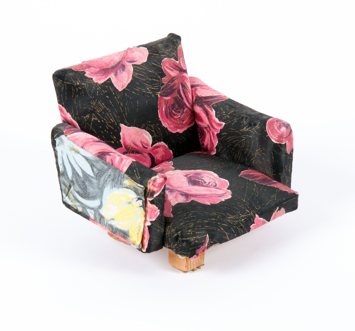 Dukkemøbler, sofa, bord og to stoler. Sofa og stoler er polstret og trukket med blomstret trekk. Bord av lakkert kryssfiner.