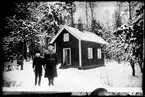 Kvinna och pojke framför hus