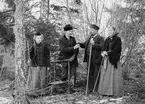 Inför skridskofärd på Sandfjärden i Sankt Anna 1899. Från vänster står Konstansia, dotter till fiskaren Viktor Jönsson som erbjuder snus till förre skepparen Anders Österman. Vid sidan om honom står hans hustru Ida med stockskridskor i handen.