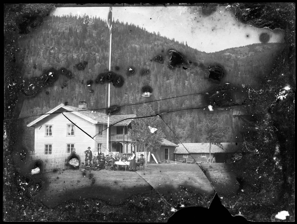 Fotosamling etter Øystein O. Kaasa. (1877-1923). Gruppeportrett foran gårdsbebyggelse. 
Kaasa ble født i Bø i Telemark på husmannsplassen Kåsa under Vreim. Han gikk først i lære som møbelsnekker, forsøkte seg senere som anleggsarbeider og startet etterhvert Solberg Fotoatelie i Seljord, (1901-1923). Giftet seg i 1920 med Sigrid Pettersen fra Stavern. Han ble av mange kalt "Telemarksfotografen".
Kaasa fikk to sønner Olav Fritjof (1921-1987) og Erling Hartmann f 1923. Olav Fritjof ble fotograf som sin far, og drev Solberg Foto i Staven 1949, Sarpsborg 1954 og Larvik fra 1960. Hans sønn igjen John Petter Solberg drev firmaet frem til 1990.