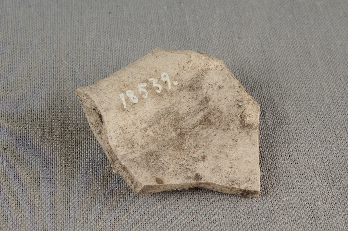 Skärva av drejat rhenskt stengods med ribbad dekor. Fragment från övre delen av ett kärl.