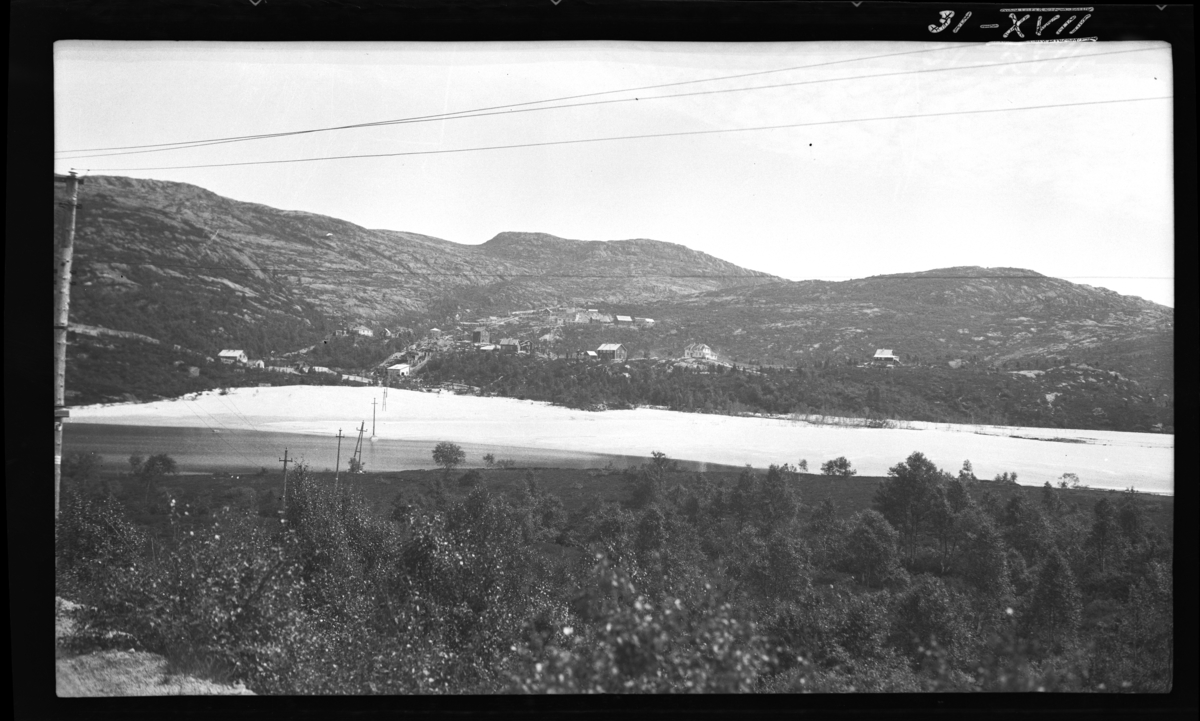 Knabeåni. "'Snøfonna' midt i bildet er avfallsmasse (knust stein) fra knuseriet. En del av denne knuste stein er omtrent sså finkornet som skurepulver, og kan sees som sand så langt ned som til Knabehøl i Kvina."