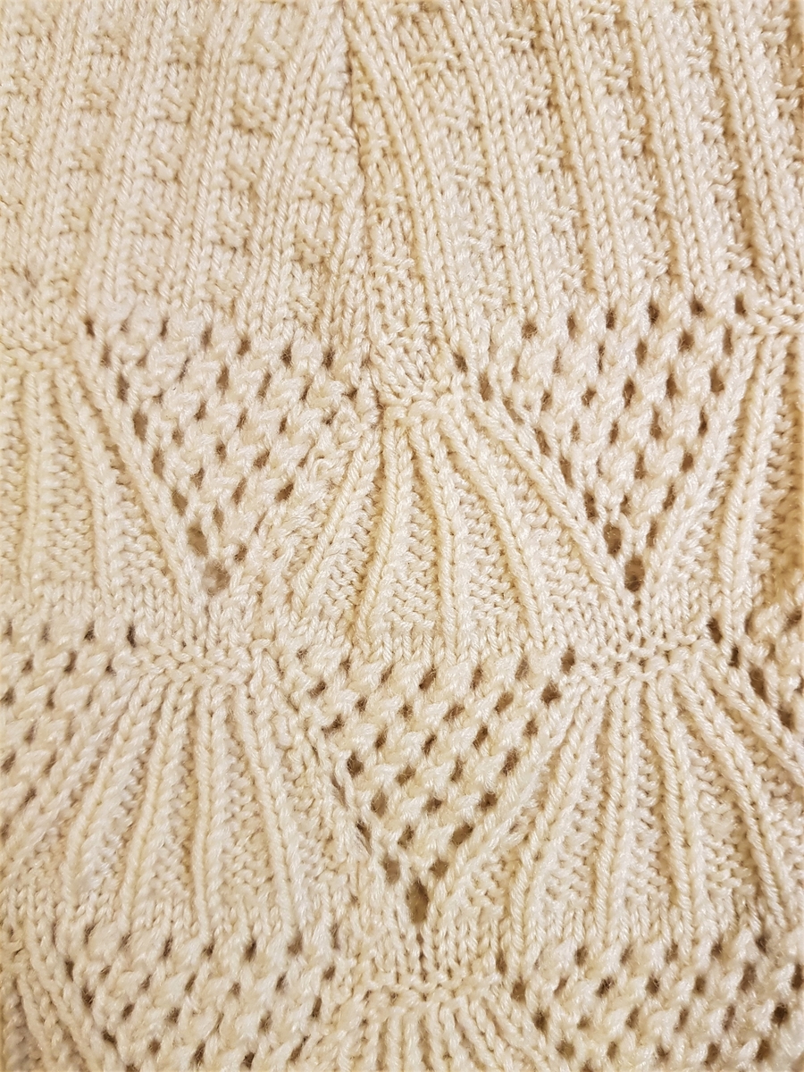 Smalt, men lett utskrådd underskjørt, strikket av gulhvit ullgarn. Hullrad med tvunnet ullsnor i livet, og "stripestrikket" ned til den nedre delen, der skjørtet avsluttes med et bredt parti mønsterstrikket, viftelignende mønster, kantet ytters med en hullbord. Skjørtet har vært omsydd og har søm midt bak med rikelig sømmonn. Sømmen når ned til det viftemønstrede partiet. Skjørtet har også vært sydd inn foran, på hver side, men disse sømmene er smale og gjennomgående helt ned. Pga det vifteformede mønsteret, er sømmene sydd for hånd slik at de følger mønsterets form og ikke bryter vifteformen. Se bildene.