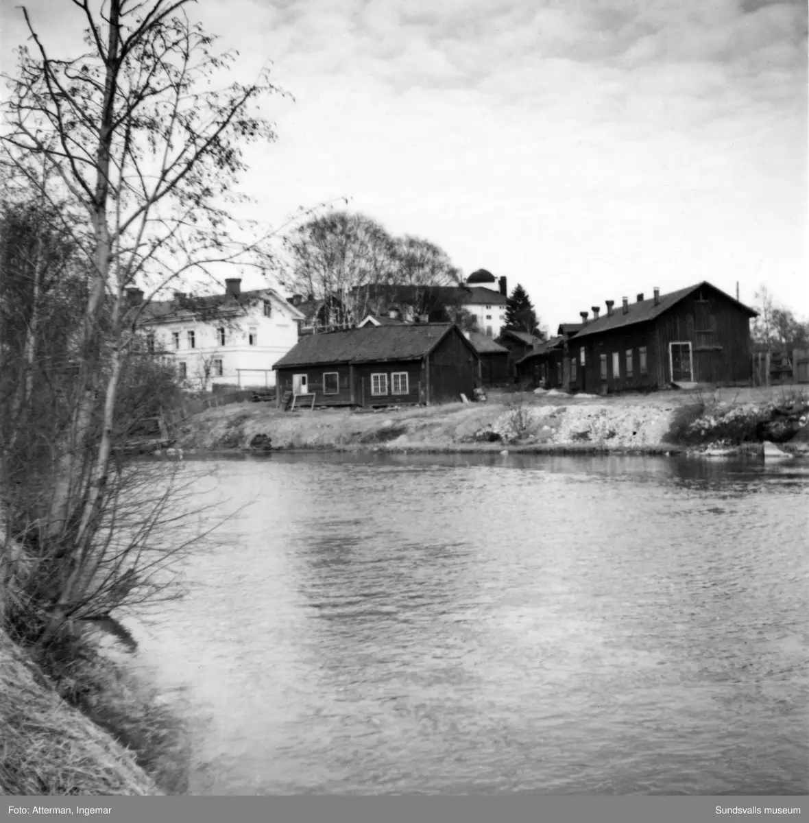 Kvarteret Västkilen sett från väster med byggnader som tidigare tillhört Bills färgeri. I det lilla timmerhuset invid Selångersån inrymdes Sundsvalls allra första vinfabrik, en verksamhet som senare flyttades till en större byggnad i hörnet av Storgatan-Sidsjövägen (det hus som senare flyttades till Norra Stadsberget).