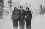 Porträttfoto av tre kvinnliga luftbevakare stående utomhus vintertid, 1942. Klädda i uniform. Från vänster Birgit Johansson, Valborg Holmberg samt Inger (efternamn okänt). Luftbevakarna tillhörde 91:a ls-kompaniet i Tellejåkk, Kåbdalis under beredskapsåren.