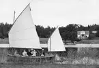 På utflykt med segelbåt i Sandfjärden, Sankt Anna. I bakgrunden ser vi lantbrukaren, fotografen och fruktodlaren Emil Durlings bostad Strömmen.

Anm: Identiterna av personerna på fotot har inte kunnat styrkas.