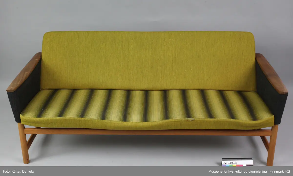 Sofaen er en treseter. Sitteflaten består av en ramme i tre. Den er på undersiden stivet av med to buede, grå lakkerte metallstenger. Polstringa holdes av gummireim som er flettet og festet til ramma. Polstringa består av skumgummi og er, på lik måte som gummireimene, svært uttørket og degradert. De er ikke lenger elastiske og smuldrer opp selv ved forsiktig berøring. Sofaen har fire runde bein. Bakbenene skrår utover. Beinene er forbundet med avrundede traverser. Armlenene er lukket og avsluttes øverst med organisk avrundede og buede trelister. Alle synlige treelementer er overtrukket med transparent lakk. Armlenene er trukket med mørkegrå, melert stoff, ryggen med grønn stoff og sitteflaten har et vertikalt stripemønster i grønn og grå. 