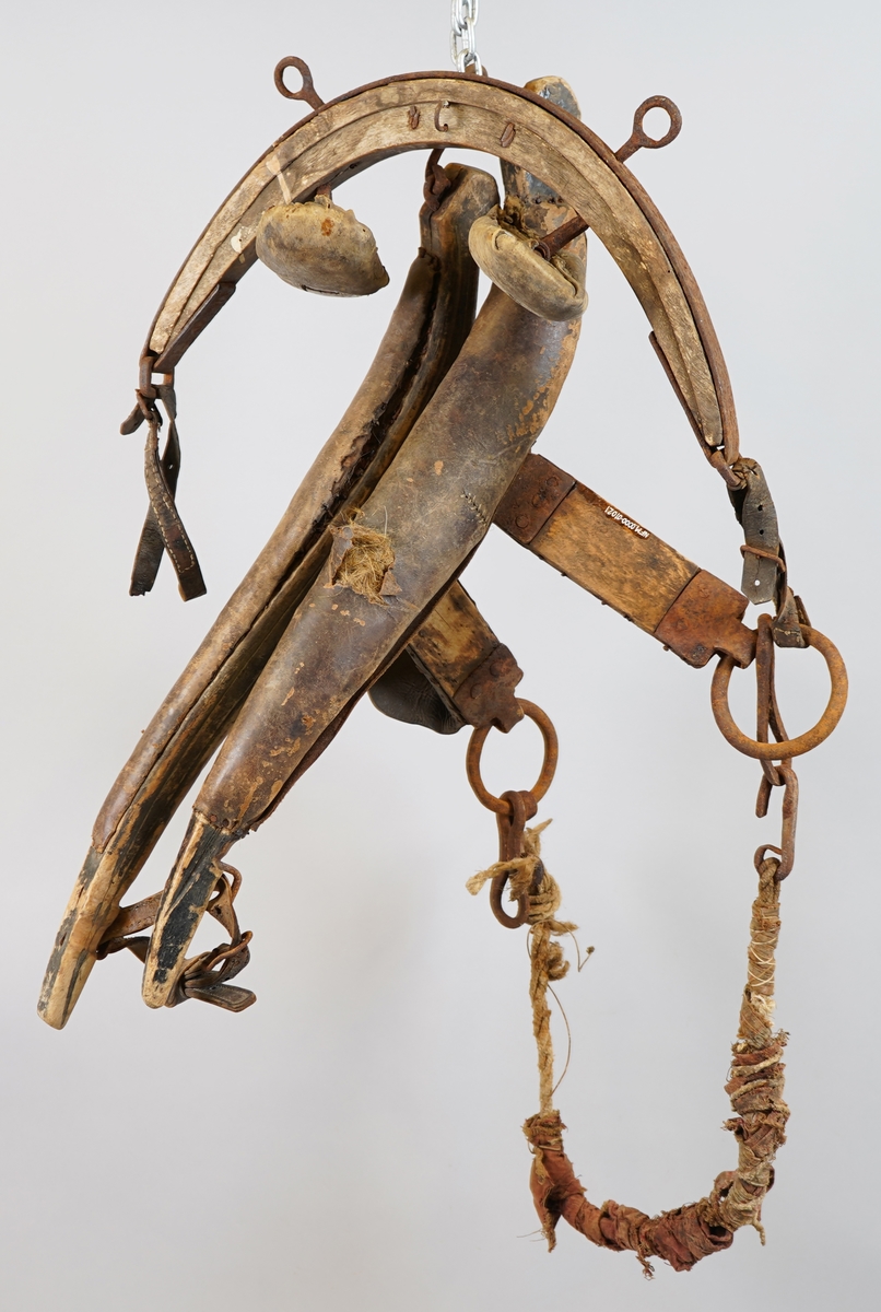 Seletøy til hest. Delar av arbeidssele: Bogtre i tre med polstra skinnputar (truleg polstra med grisebust). Drott (dragreim) av tre fest i bogtreet med jarn. Høvre av tre med jarn og puter av tre polstra med skinn. Tau polstra med tekstil, med jarnkrokar i kvar ende, er festa til ring i eine enda på dråttet.
Delane er hekta inn i kvarandre.