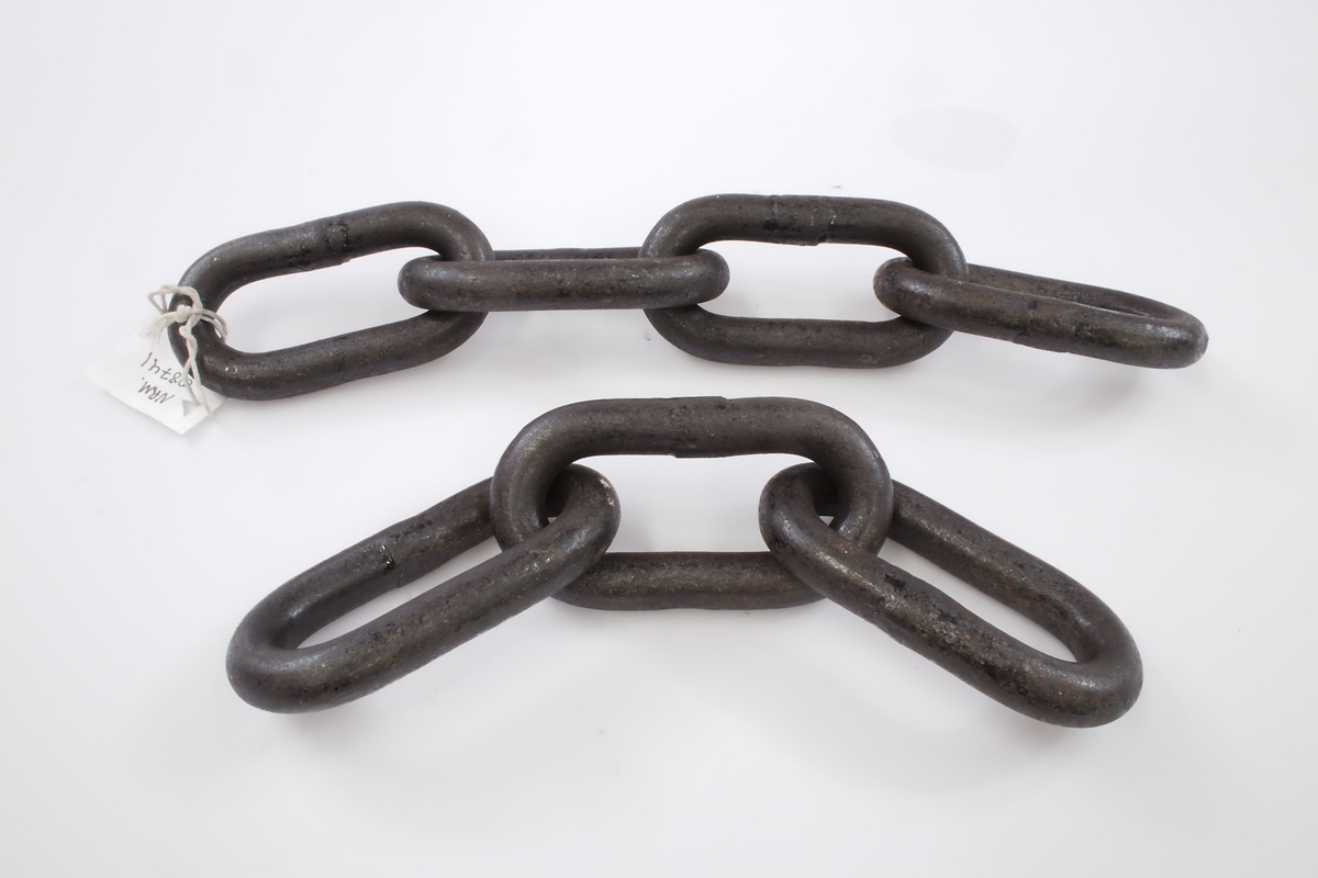 To korte lenker, en jernring, to rør. Rørene er såkalte "muffer". Jernringen er et midjejern. Nøkkelen til midjejernet medfølger.