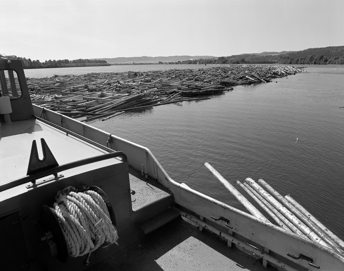 Slepebåten «Rauma» i arbeid med tømmer som skulle bukseres ut av det grunne farvannet nedenfor lenseanlegget ved Glommas utløp i innsjøen Øyeren ved Fetsund. Dette fartøyet ble bygd ved Knardalstrand Slip & Verft i Porsgrunn i 1959, etter tegninger som Richard Furuholmen og Otto Scheen hadde utført i samarbeid med fløtingsingeniøren Kjell Bering.  Rauma var 12,24 meter lang, 5,4 meter bred og veide 20 tonn. Den nye Rauma hadde en kraftig dieselmotor. Fram til 1971 ble den nye Rauma, som den gamle, brukt til å buksere tømmerpartier fra vindskjermen ved Vestvollen til den lokale industrien. Etter at denne industrien ble nedlagt ble denne båten i hovedsak brukt til å styre den bakre delen av «nedleggene» – lange kjeder av «sopper» – som ble slept forsiktig gjennom de grunne og svingete elevefarene i deltaområdet nedenfor Fetsund lenser mot Sofiedal eller Engelsvika i Rælingen, der nedlegget ble fortøyd mens de store slepebåtene Isnæs og Mørkfos, hentet nye «nedlegg» med bistand fra Rauma. To og to nedlegg ble bundet sammen til «vendinger», som ble slept videre nedover til Sandstangen eller Sleppetangen ved Glommas utløp av Øyeren. Det hendte også at Rauma gikk helt ned til sørende av Øyeren. Det var denne båten som slepte de aller siste stokkene fra lenseanlegget og sørover da fløtinga ble avviklet i 1985.  Rauma ble seinere overtatt av museet ved Fetsund lenser, som fikk finansiert en restaureringsprosess i 2004-2005. Museet bruker Rauma som arbeidsbåt i under vedlikehold av det nå fredete lenseanlegget.
