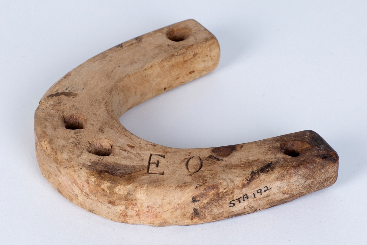 Buet form, fire (4) hull; to til rakketrossa og to til bruk ved festing av råa. Emnet er krokvokse tre.