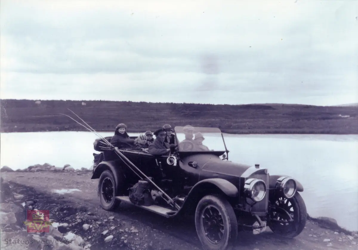 Drosjeeier Lars Bernt Lerdahl ved rattet på 7-seter Benz med registreringsnummer E-324.
Ref. til "Veteranvognføreren." Blad for Lillehammer Veteranvognklubb. s29-30.