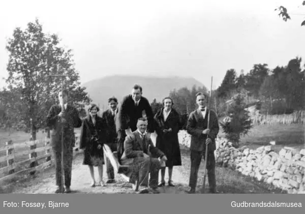 Pyntet "arbeidsfolk", kvinner og menn holder en rive hver, en mann på trillebåre.