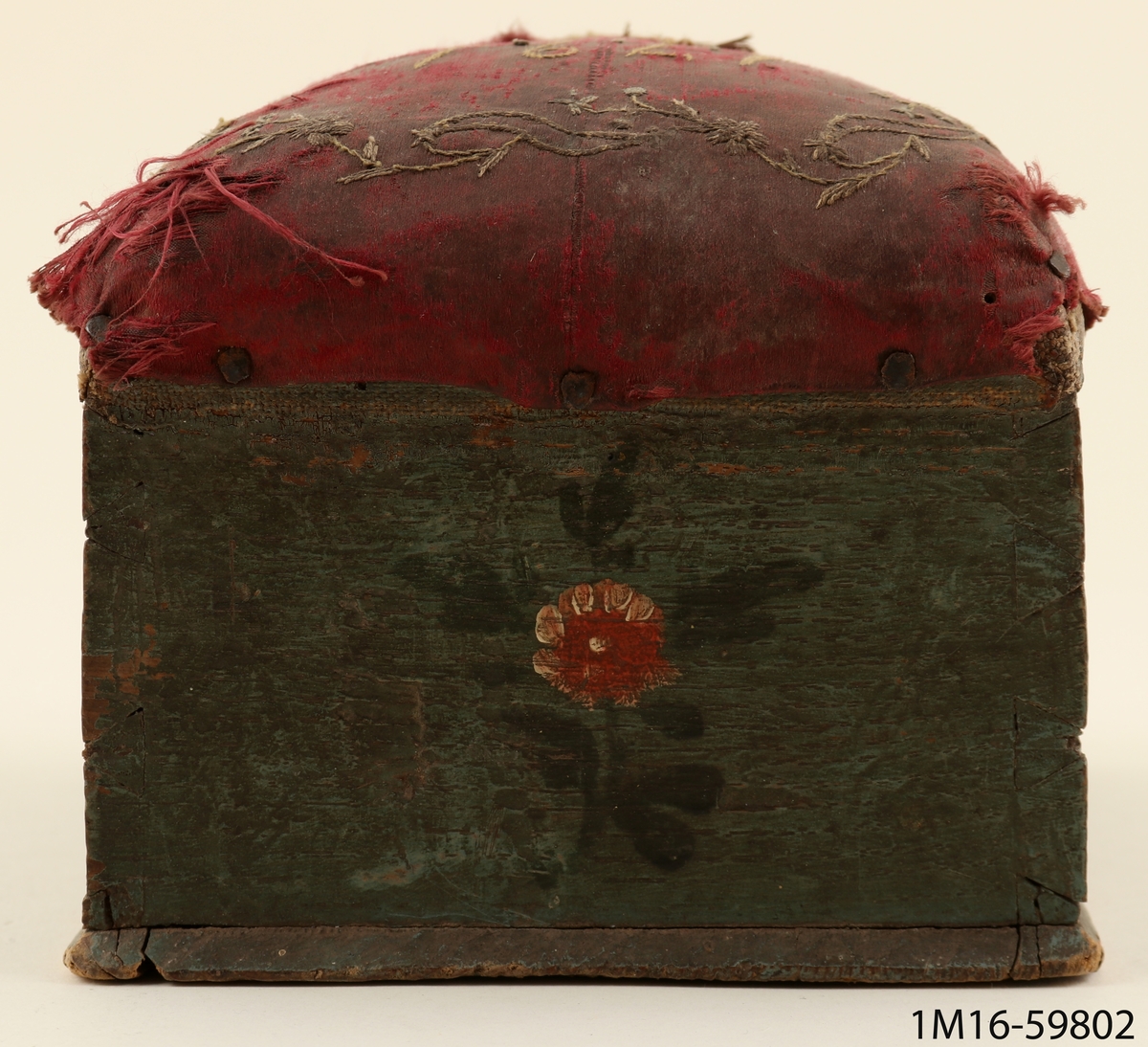 SYLÅDA AV TRÄ MED UTDRAGBAR LÅDA, MÅLAD I BLÅGRÖNT MED BLOMMOR PÅ ALLA SIDOR.  DYNA KLÄDD MED RÖTT SIDEN, BRODERAD MED SLINGOR I GULVITT SAMT 1791 OCH INITIALERNA BND.  MYCKET SLITET TYG.  LINNE UNDER SIDENET, ALLT SPIKAT MOT TRÄET.  HÅRT STOPPAD DYNA.  KULFÖTTER, 1 KVAR.