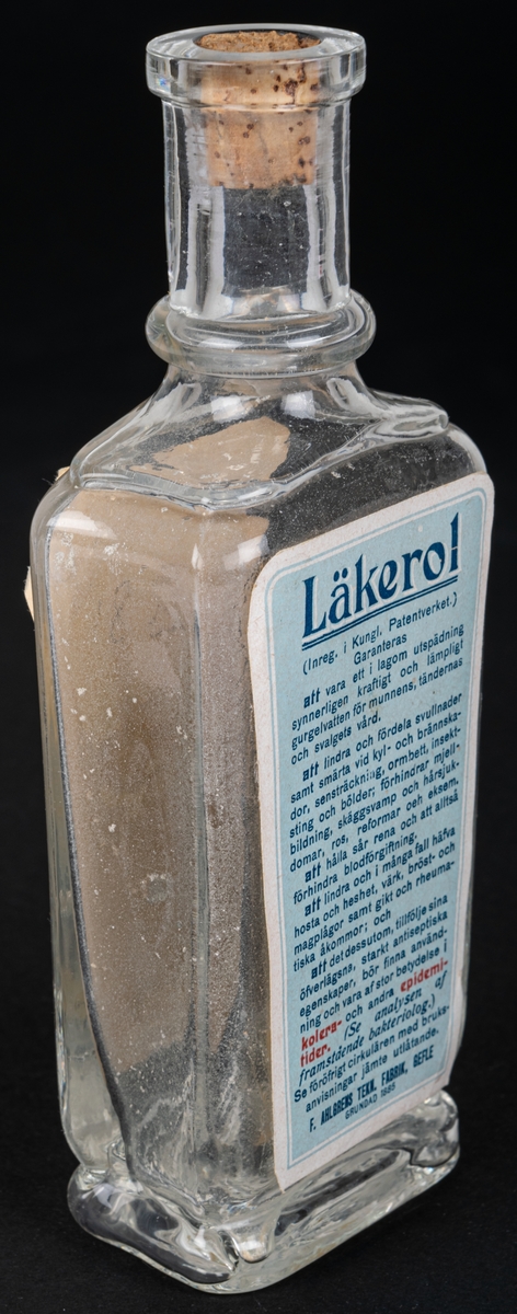 Glasflaska med kork, har innehållit anticeptiskt medel. Text bl.a: "LÄKEROL"