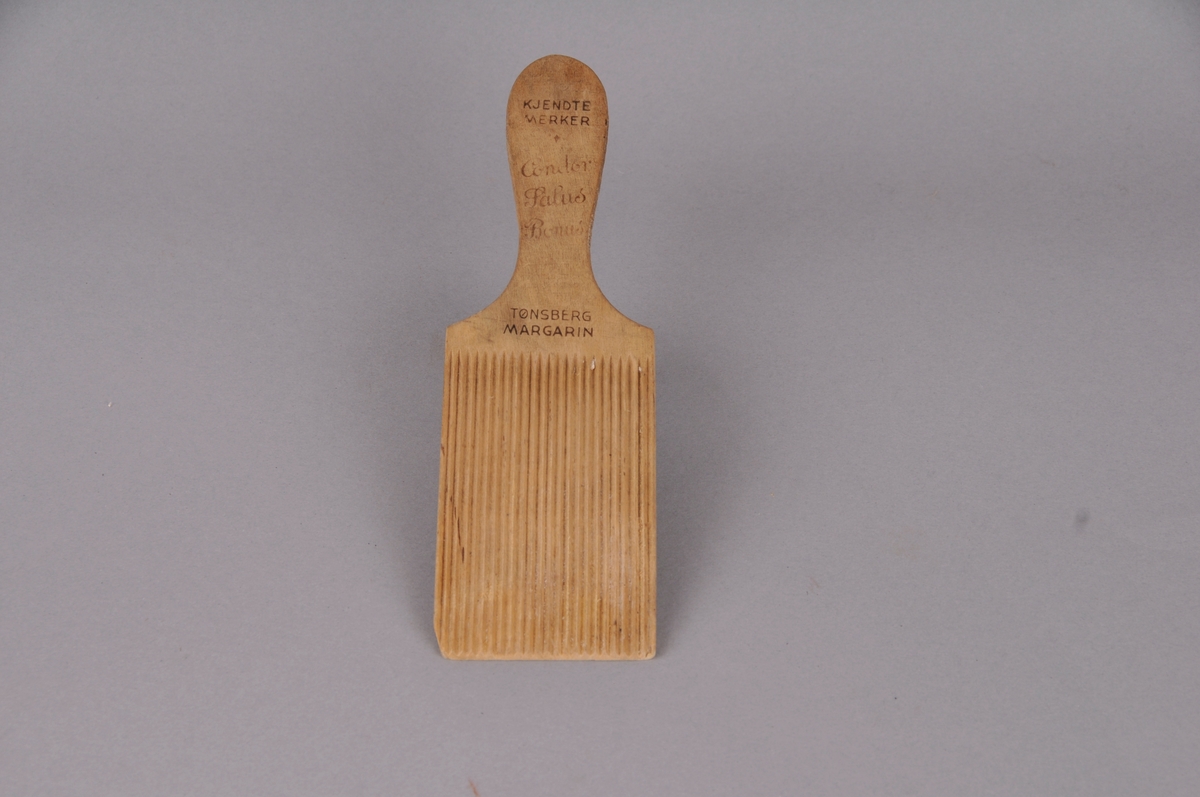 Smørspade i tre med reklametekst.