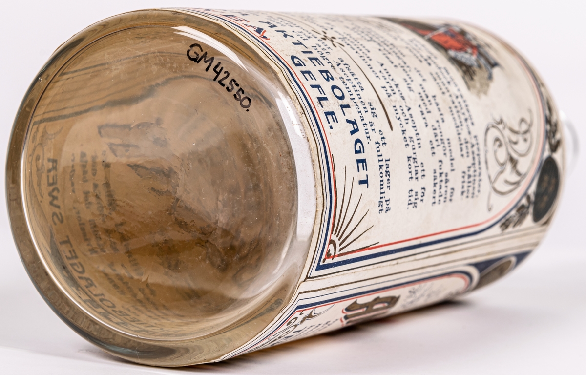 Glasflaska. 
Etikett med text; 
Tekniska aktiebolaget
Sweas Äkta
Amyktos-Aseptin. 
För toiletten.