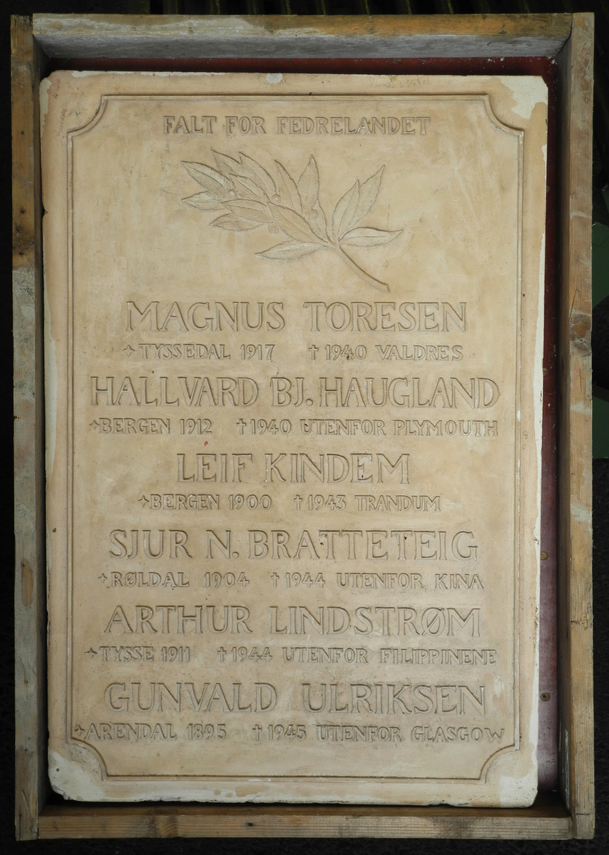 Rektangulær plate av gips med inngraverte bokstavar og motiv, negativ. 
Tekst: Falt for fedrelandet. Magnus Toresen +Tyssedal 1917  kors (død) 1940 Valdres. Hallvard BJ. Haugland + Bergen 1912  kors (død) 1940 Utenfor Plymouth. Leif Kindem + Bergen 1900  kors (død) 1943 Trandum. Sjur N. Bratteteih + Røldal 1904 kors (død) 1944 Utenfor Kina. Arthur Lindstrøm + Tysse 1911 kors (død) 1944 Utenfor Filippinene. Gunvald Ulriksen + Arendal 1895 kors (død) Utenfor Glasgow. 