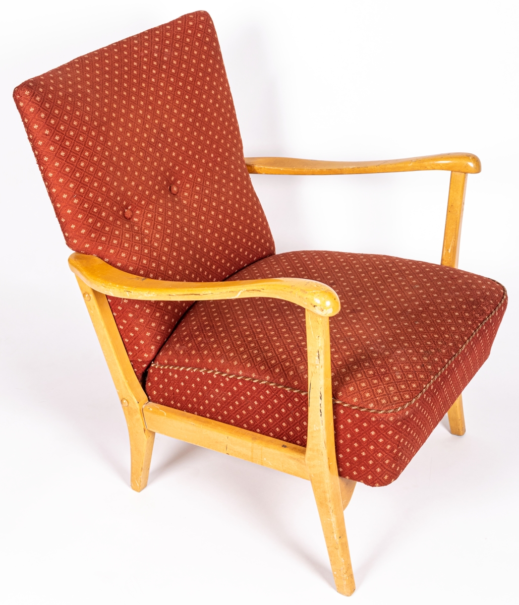 Katalogkort: Fåtölj. Ljust träslag i armstöd och ben. Sits och ryggstöd klädda med mönstervävt tyg. Varp: röd. Inslag: rett, vitt. Gåsögonliknande mönster. Sitsens kant, kantad med snodd i rött och vitt. På stolsryggens framsida fanns ursprungligen 3 textilklädda knappar, varav en saknas.

h 80cm, b 66cm, dj 77cm