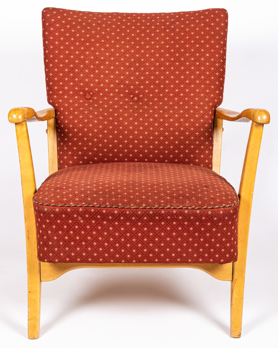 Katalogkort: Fåtölj. Ljust träslag i armstöd och ben. Sits och ryggstöd klädda med mönstervävt tyg. Varp: röd. Inslag: rett, vitt. Gåsögonliknande mönster. Sitsens kant, kantad med snodd i rött och vitt. På stolsryggens framsida fanns ursprungligen 3 textilklädda knappar, varav en saknas.

h 80cm, b 66cm, dj 77cm