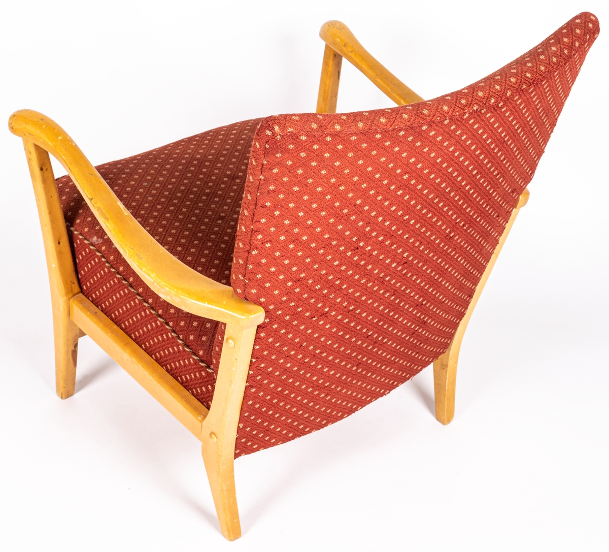 Katalogkort: Fåtölj. Ljust träslag i armstöd och ben. Sits och ryggstöd klädda med mönstervävt tyg. Varp: röd. Inslag: rett, vitt. Gåsögonliknande mönster. Sitsens kant, kantad med snodd i rött och vitt. På stolsryggens framsida fanns ursprungligen 3 textilklädda knappar, varav en saknas.

h 80cm, b 66cm, dj 77cm