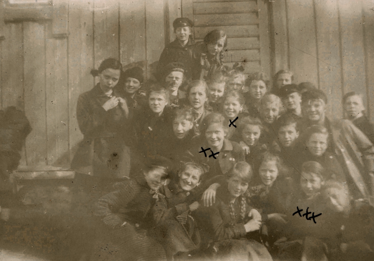 Portrettfotografi av ei skoleklasse utenfor et hus.