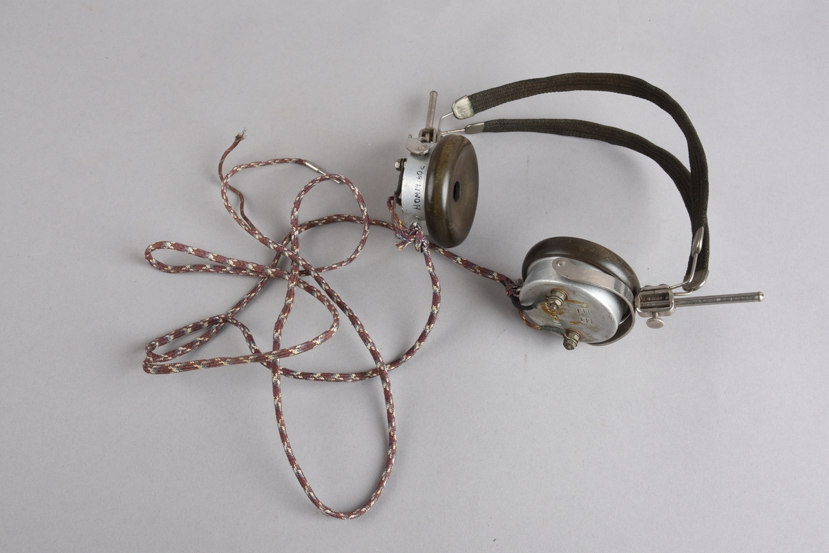 Radiomottakar, krystallapparat med to sett med hovudtelefonar. Apparatet er montert i ei trekasse med kvadratisk grunnflate, loddrette bak- og sideveggar. Framsida skrår bakover opp mot ei smal topplate. Panel på framsida med krystall montert på toppen, i midten ei dreibar skive med tal frå 0 til 180. Koplingspunkt for hovudtelefonar, antenne og jord.
To par hovudtelefonar som begge er sett saman av hovudbøyel og høyreklokker som er festa til metallstativ som gjev rom for regulering av høgde og vinkel på hovudtelefonane Hovudtelefonane har leidning for tilkopling til krystallapparatet.