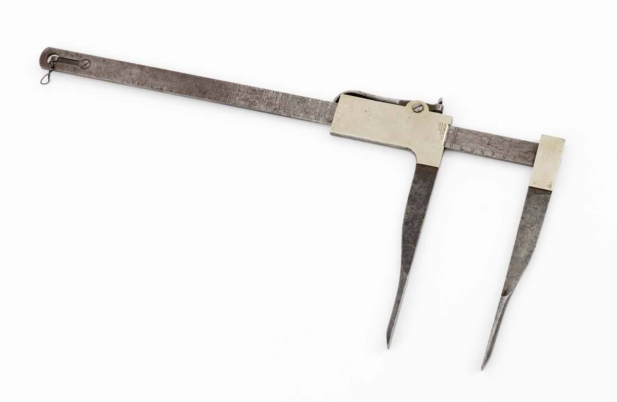 Skyveklave for diametermåling og volumberegning tømmer, altså en såkalt «kubikklave». Redskapet er lagd av stål. Det har en 52,3 centimeter lang, rett linjal med rektangulært tverrsnitt (2,4 X 0.4 centimeter). I den ene enden er det påtappet en rettvinklet 20,3 centimeter lang klavearm (målt langs innersida, 23,4 centimeter utvendig) som smalner noe mot ytterenden. Klaven har også en bevegelig arm med samme lengde og samme vinkling i forhold til linjalaksen. Denne armen er smidd sammen med en fal som tjente som handtak når den bevegelige klavearmen skulle posisjoneres under målingsarbeidet. På tverrenden av denne komponenten er det montert en fjærbelastet stålhendel, der endeleddet, ved hjelp av en vingemutter i den andre enden, kan låses i en bestemt posisjon, basert på tommemål på klavelinjalens tverrende. På den ene sida av aluminiumsdekselet på handtaket er romertallene IIIX, IIX, IX og X innstemplet. På den andre sida finner vi tallrekka XIV, XV, XVI, XVII og XVIII. Disse tallene refererer antakelig til relevante lengdemål på tømmerstokker, oppgitt i halvmetere. Ved å sammenholde disse tallene med tallrekker på klavelinjalens langsider kunne man lese av stokkvolumene, målt i liter. Den ene flatsida har også en diameterskala i centimeter, mens tommediametere avleses på linjalens tverrende. Alle mål avleses ved den bevegelige klavearmens innerkant. Ved bruk av diameterklave sparte tømmermålerne mye kontorarbeid med volumberegninger med utgangspunkt i lengde- og midtmål. Produsentens stempel er plassert på en av klavelinjalens ytterender.

Denne klavetypen skal være konstruert av Ole S. Øvergaard (1873-1945) fra Lillestu Koppang i Stor-Elvdal, som på dette tidspunktet var driftsbestyrer på Evenstad skogskole i Stor-Elvdal. Den ble mønsterbeskyttet i 1914. Bare de første kubikklavene hadde volumer angitt i hele liter, senere grovere inndeling.