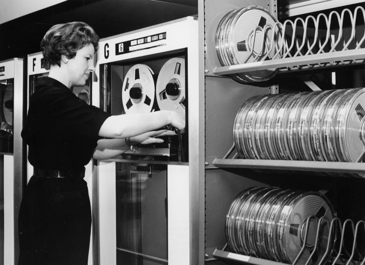 Bokföringsavdelningens datacentral. Vid bandstationen arbetar Gunnel Kupferschmidt. På magnetbandet sorteras uppgifterna samtidigt upp i nummer- och serieordning, och man får så fram det s k omsättningsbandet.

IBM 729 Magnetic tape Unit for IBM 1014 Data Processing System.