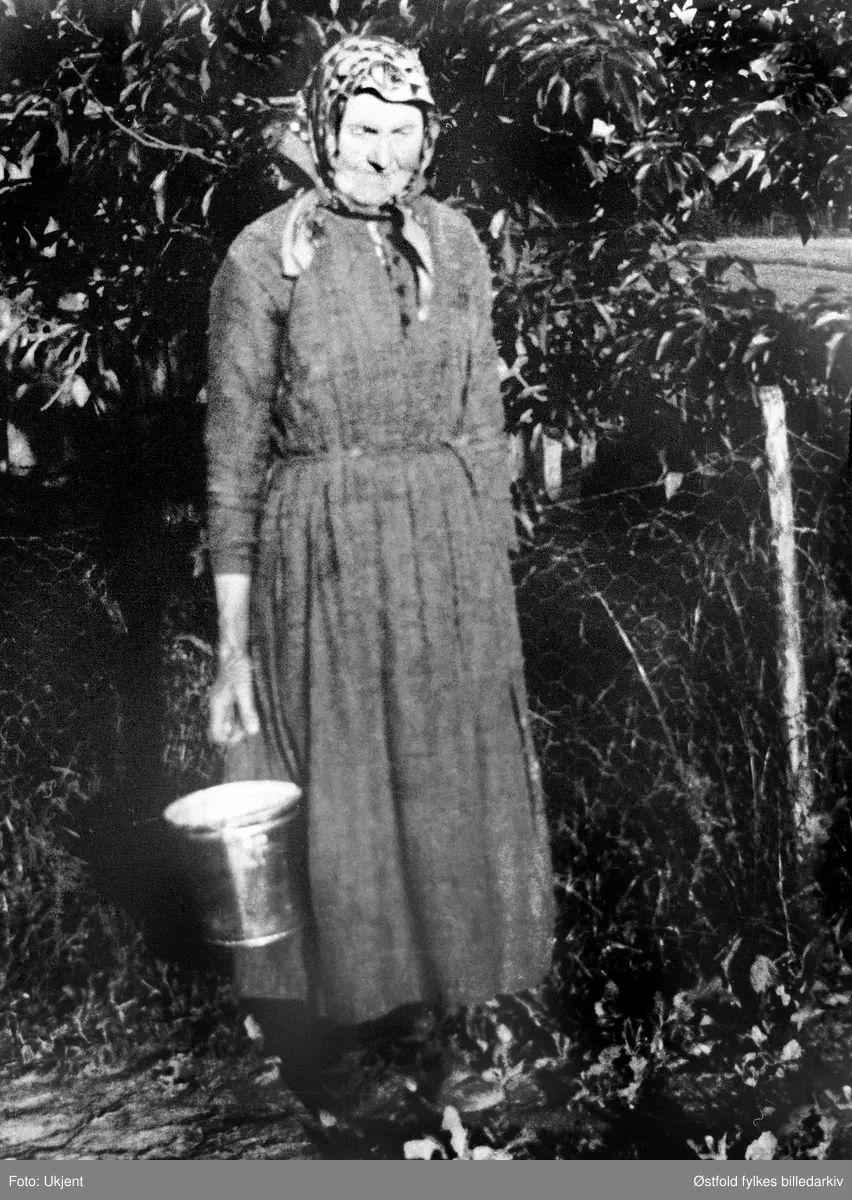 Mathea Kassem f. 1860 bærer vann, ved brønnen til gården Kassem i Skiptvet ca. 1923.