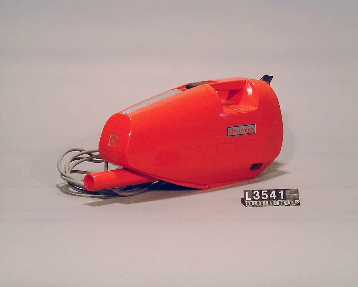 Röd handdammsugare i plast, med dammindikator.