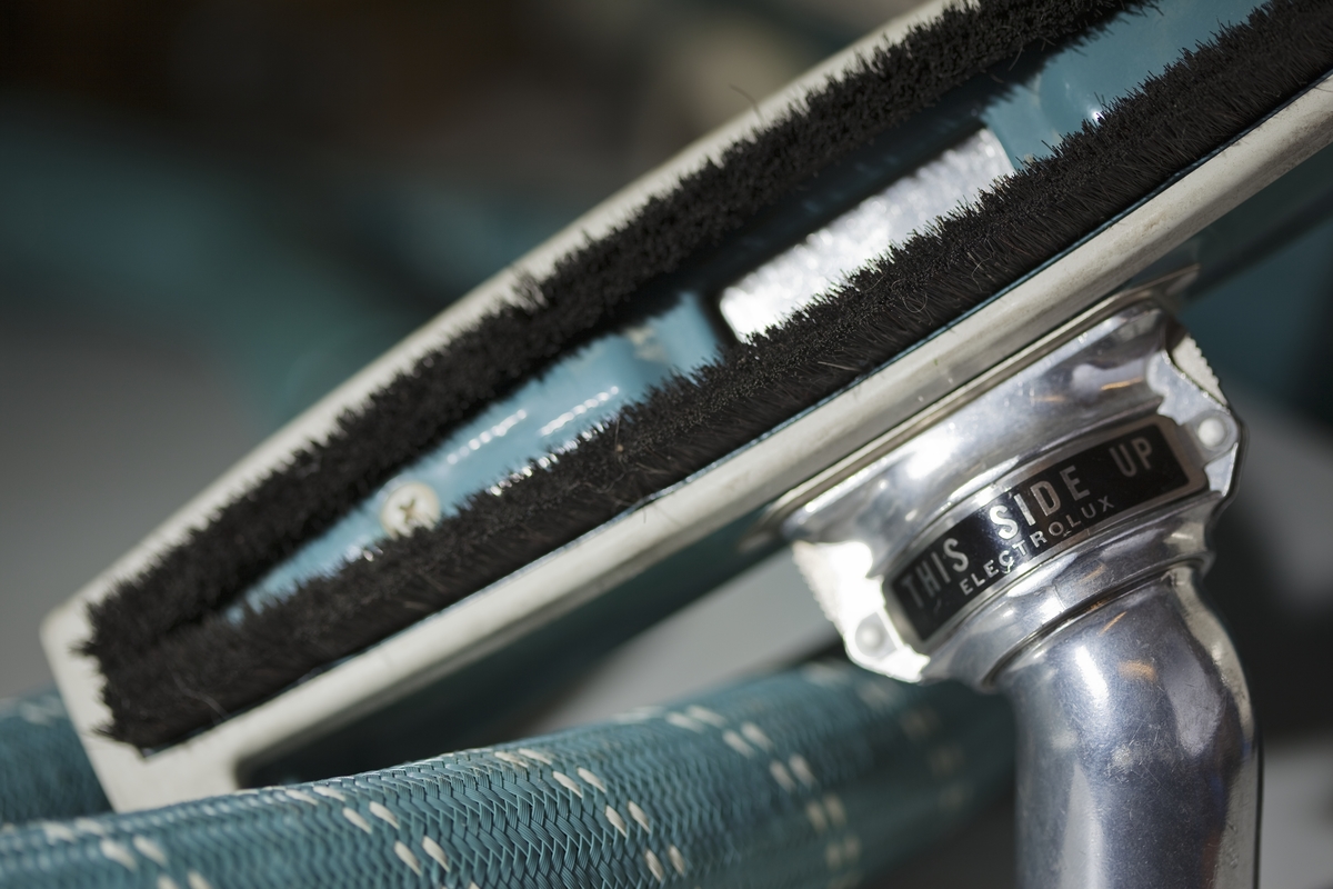 Blå metallicfärgad dammsugare på hjul med fram och bakparti i vit plast. Stötdämpare i plast med Electrolux på sidan. Slang, rör och munstycke följer maskinens färgskala. Dammsugaren har kabelvinda, dammindikator och dammbehållare i papper.