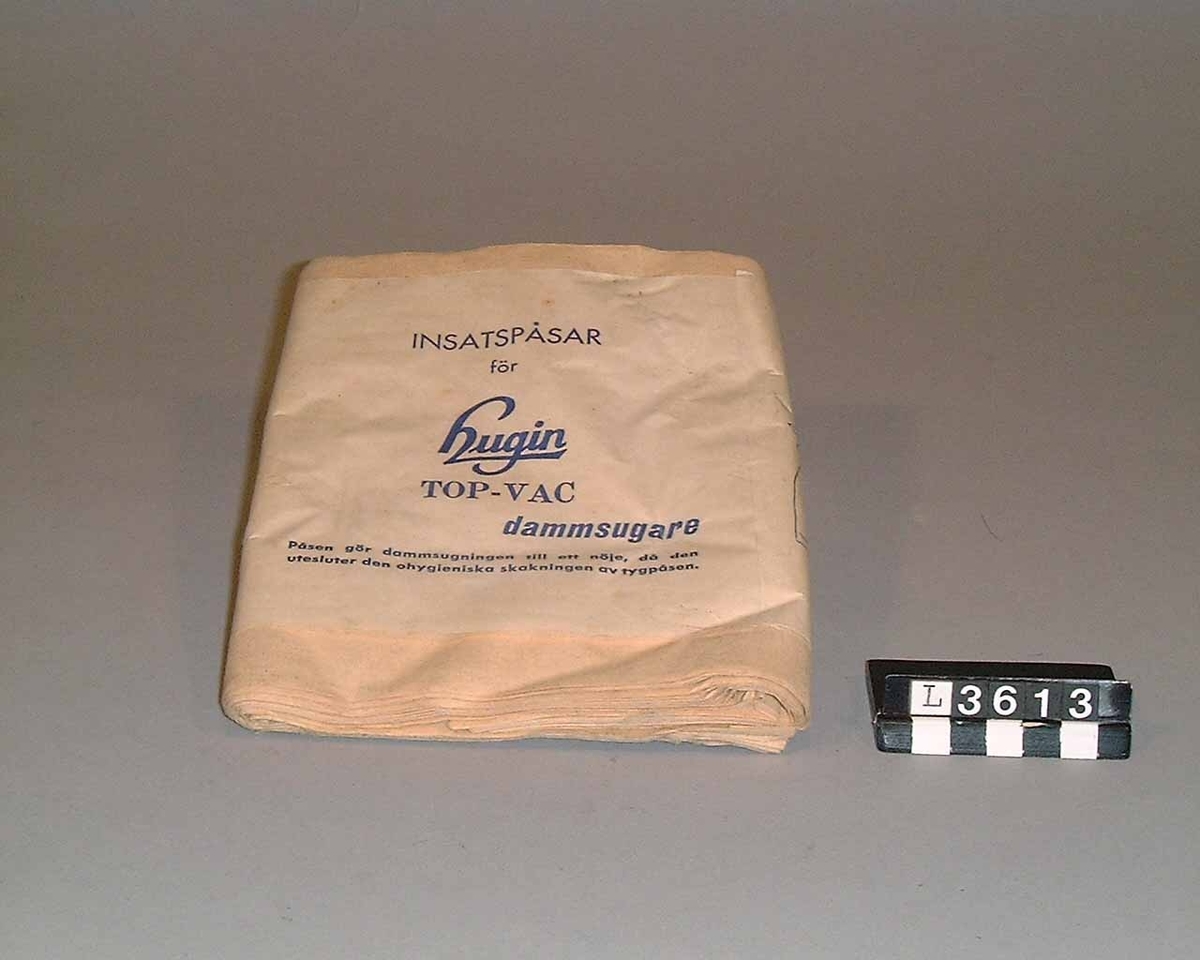 Dammsugare av märket Hugin helt i plast. Ovandelen är i ljusgrå plast, medan underrede och framlucka är i blå plast. Maskinen saknar bricka med tillverkninguppgifter. Slang, rör och munstycke saknas.
Tillbehör: Dammsugarpåsar.